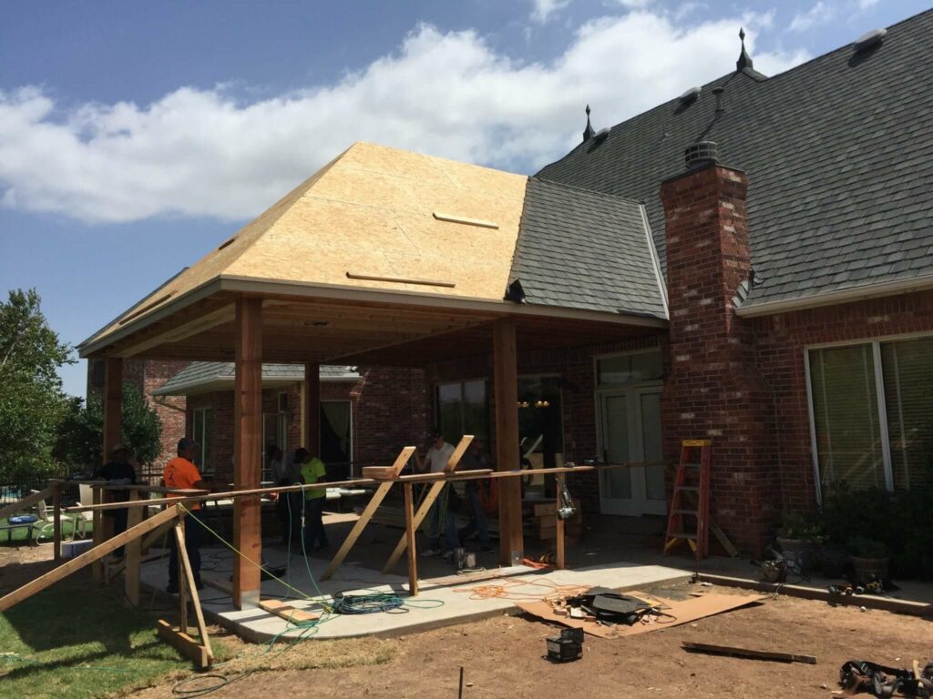 Patio addition constructed with new roof, framing, concrete, painting, cedar posts, speakers, lighting, and power screens.