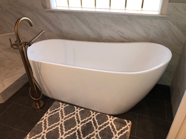 New stand-alone tub with custom gold faucet.