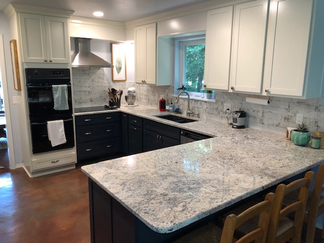 This kitchen remodel includes new upper and lower cabinets (two colors), hood and granite.