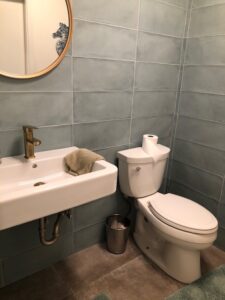 New utility bathroom, drywall, stunning wall tile, floor tile, and floating sink.
