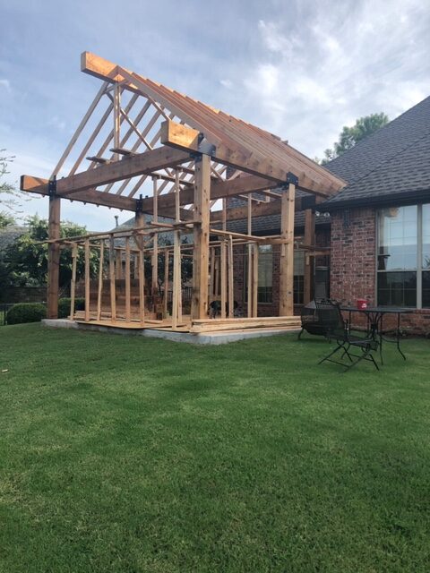 Photo of framing for covered patio with cedar columns and beams.