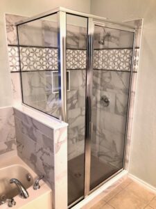 New tub and shower tile. New glass door. Custom border inlay tile. Schluter system.