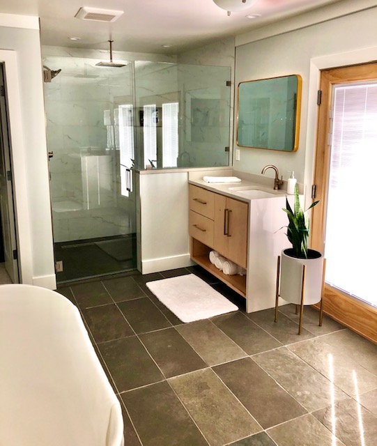 New master bathroom and closet addition. Walk-in shower with limestone tile floor and porcelain wall tile. Stand-alone deep tub. Custom-built vanities with quartz countertops.