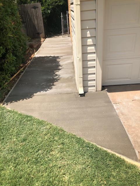 Concrete sidewalk on the side of a house.