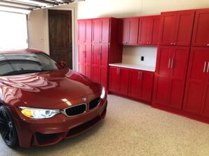 Custom built garage cabinets with quartz countertop and bright red paint!