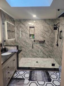 Beautiful fully remodeled bathroom with custom lit mirrors and tile.