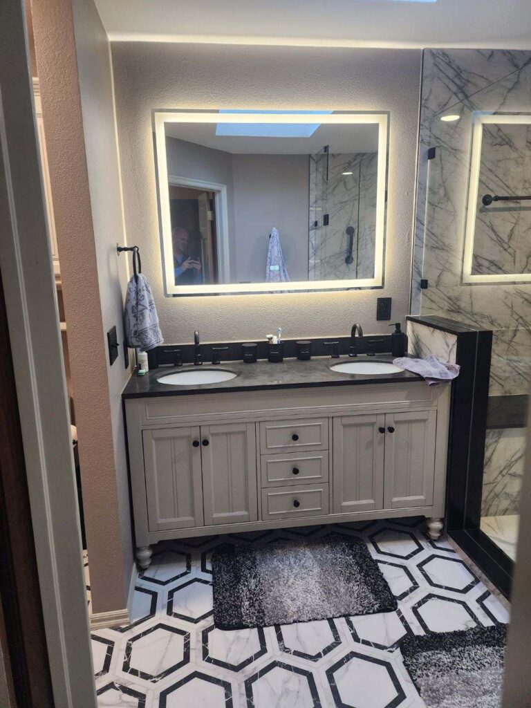 Beautiful fully remodeled bathroom with custom lit mirrors and tile.