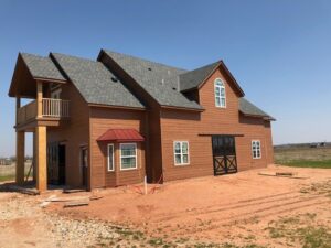 Exterior view of a newly built Barndominium with custom horse stalls on the lower level and living quarters above.